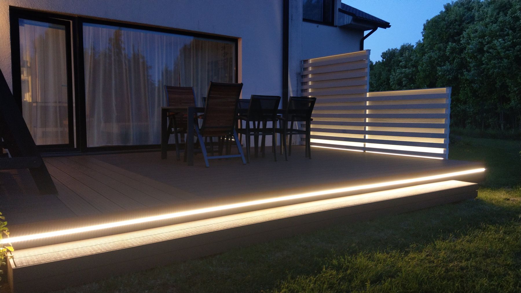 Composite decking with illuminated sub-structure at dusk